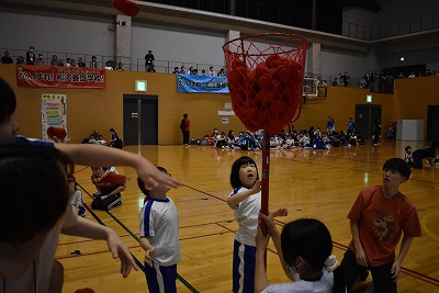 低学年競技、玉入れで一生懸命球を入れる児童たち