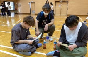 ビンゴ大会で数字を探す卒業生