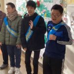 昇降口で下校する生徒たちにあいさつをする生活委員会の生徒たち