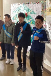 昇降口で下校する生徒たちにあいさつをする生活委員会の生徒たち