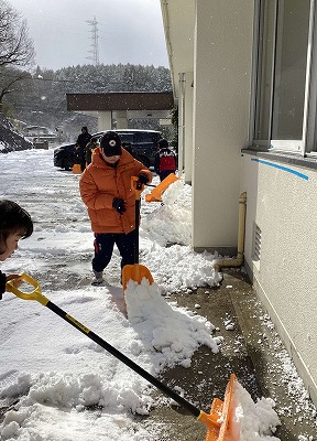 ショベルで雪かきをする児童たち
