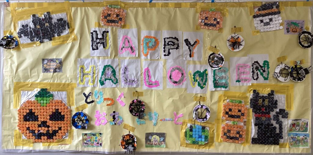 ペットボトルで描かれた蝙蝠、かぼちゃ黒猫に真ん中に、「HAPPY HALLOWEEN」のタイトルが描かれています。